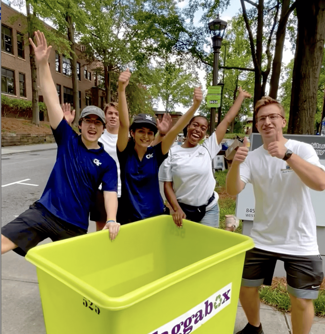 Excited volunteers stand behind move-in bin 